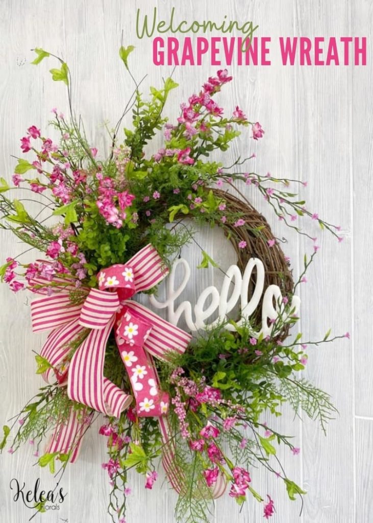 grapevine with greenery and pink floral stems with a white hello cutout