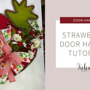 strawberry door hanger with white flowers and a bow