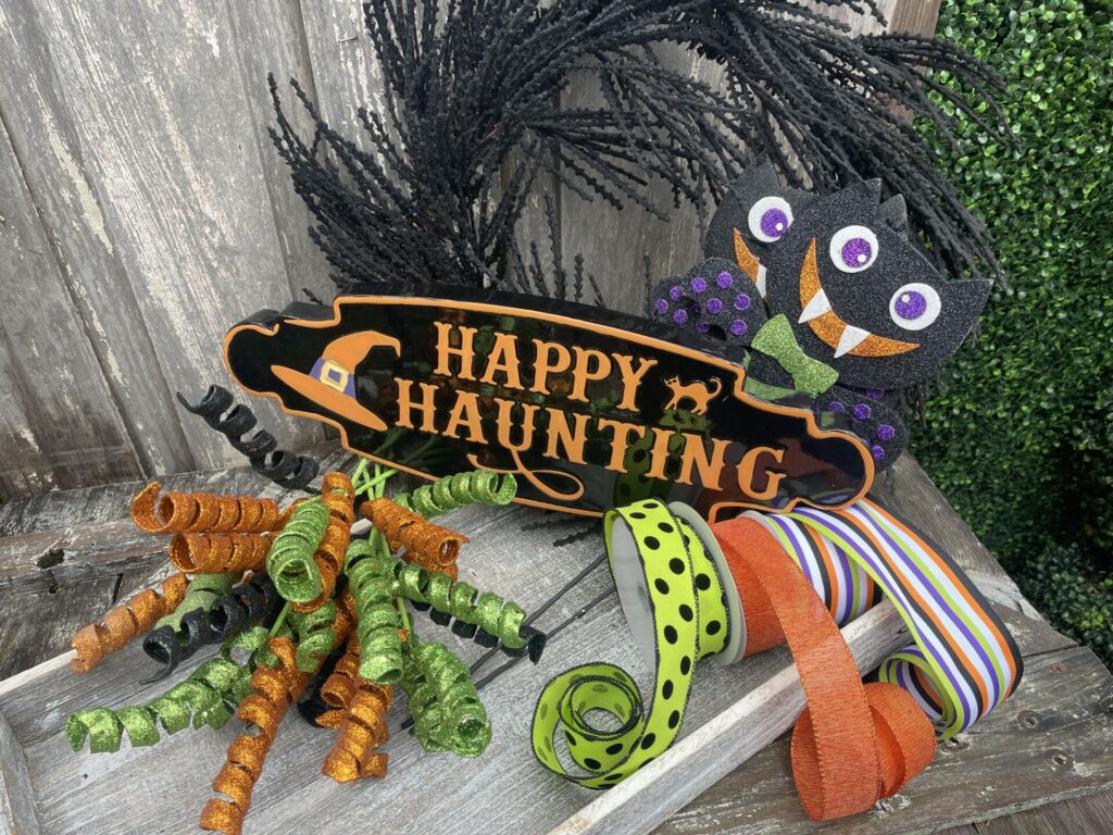 Supplies for DIY Halloween bat wreath with bats sign ribbon and curly picks