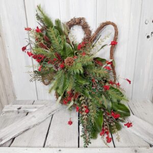 Rustic Christmas grapevine angel door swag with red berries and cascading greenery