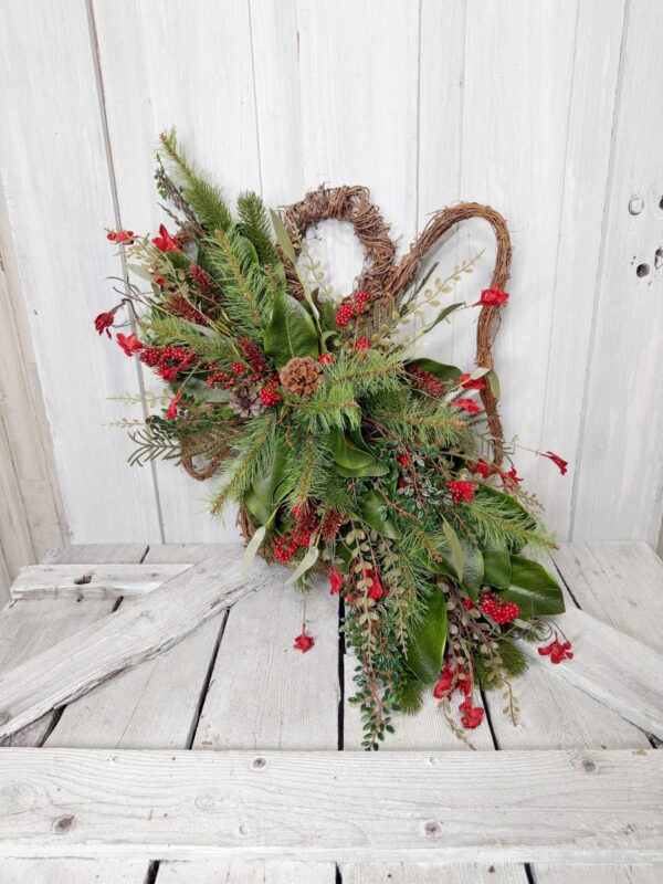 Rustic Christmas grapevine angel door swag with red berries and cascading greenery