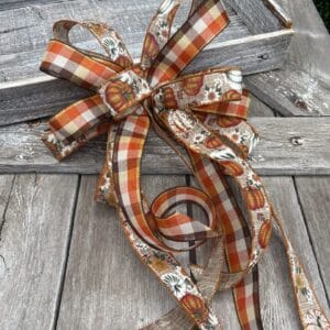 Fall loopy bow with long tails made with pumpkin and plaid ribbon
