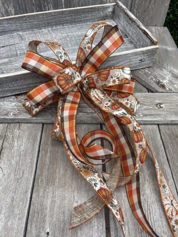 Fall loopy bow with long tails made with pumpkin and plaid ribbon
