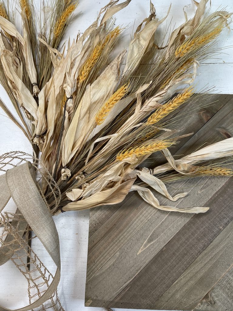 corn husks and wheat florals with textured ribbon and wood plaque