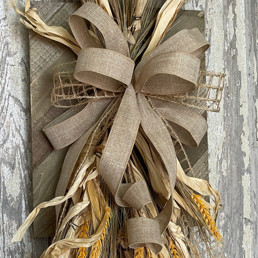 Natural burlap and open weave ribbon bow on wheat fall wall decor