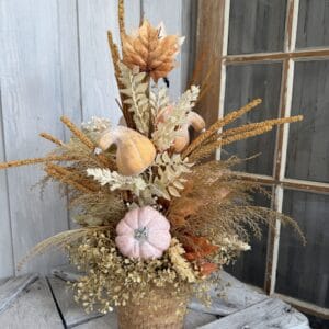 Autumn floral arrangement with pumpkins and golden fall stems