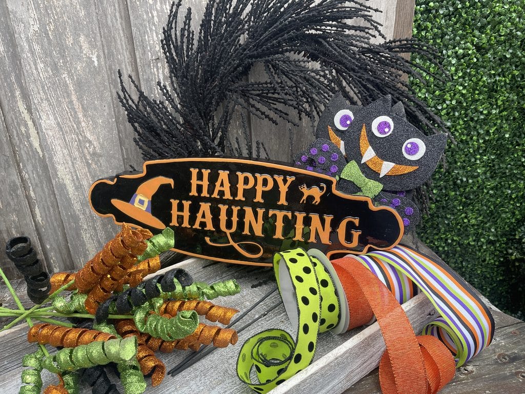 Supplies for DIY Halloween bat wreath with ribbon bats sign and glitter curls