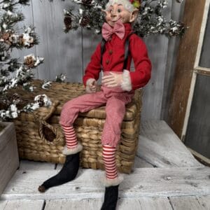 Large posable Christmas elf with red suspenders and striped pants