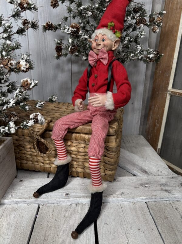 Large posable Christmas elf with red suspenders and striped pants