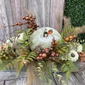 Fall natural pumpkin floral arrangement with green pumpkins, ferns, berries and autumn greenery