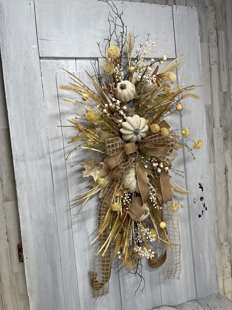 Neutral fall door swag with white pumpkins, wispy twigs and natural ribbon