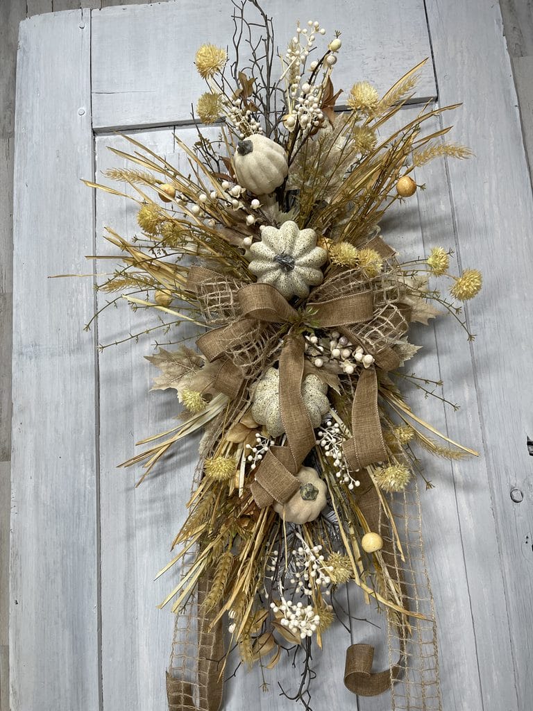 Natural windowpane and tan ribbon bow on a wispy fall swag