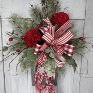 DIY Christmas floral wall decoration with snowy pine eucalyptus and red berries
