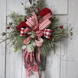 Christmas wall pocket floral arrangement with red and white ribbon winter greenery and berries