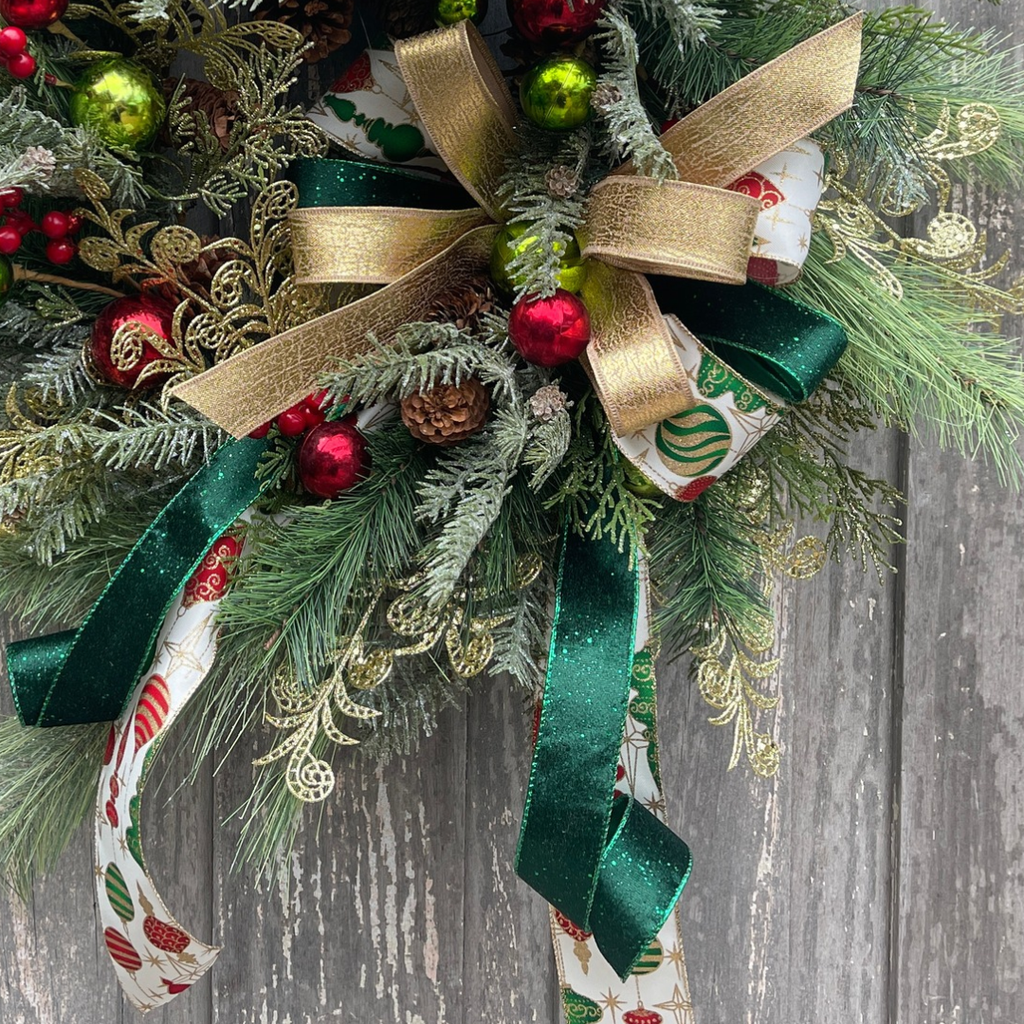 Layered Christmas ribbon bow surrounded by ornaments and pine greenery