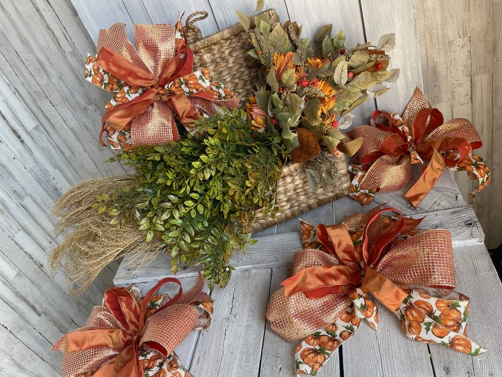 Pumpkin and gold wired ribbon bows decorating an Autumn sunflower garland
